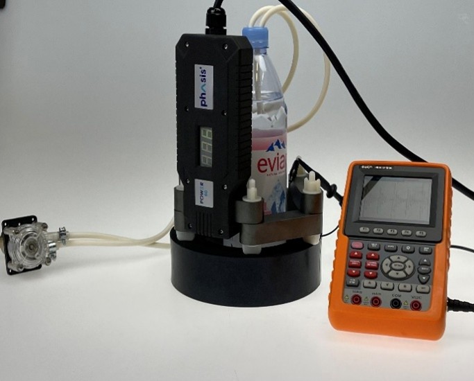 Versuchsaufbau: Phasis Gerät mit Evian-Flasche und Peristaltikpumpe